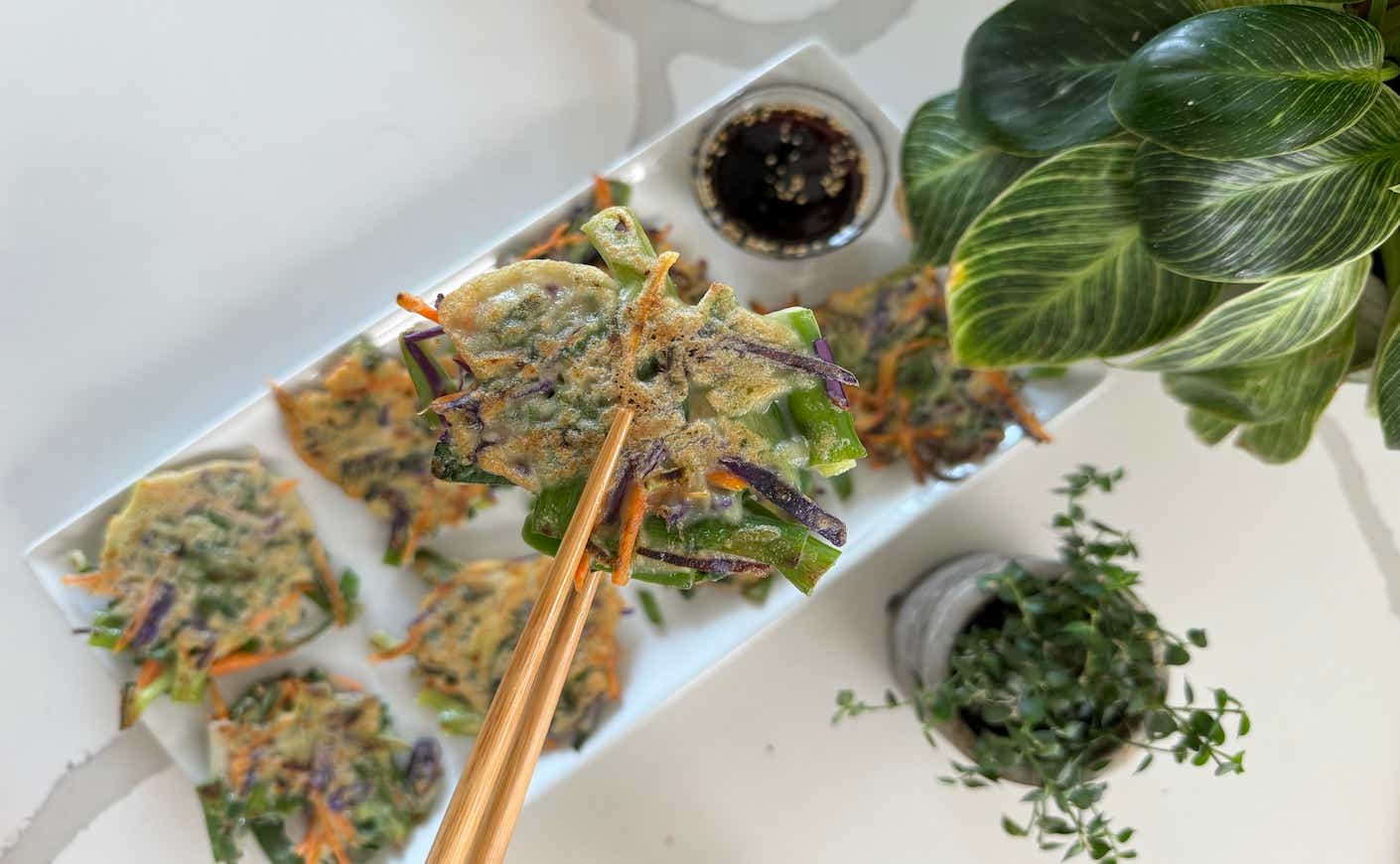 chopsticks holding up a homemade scallion pancake