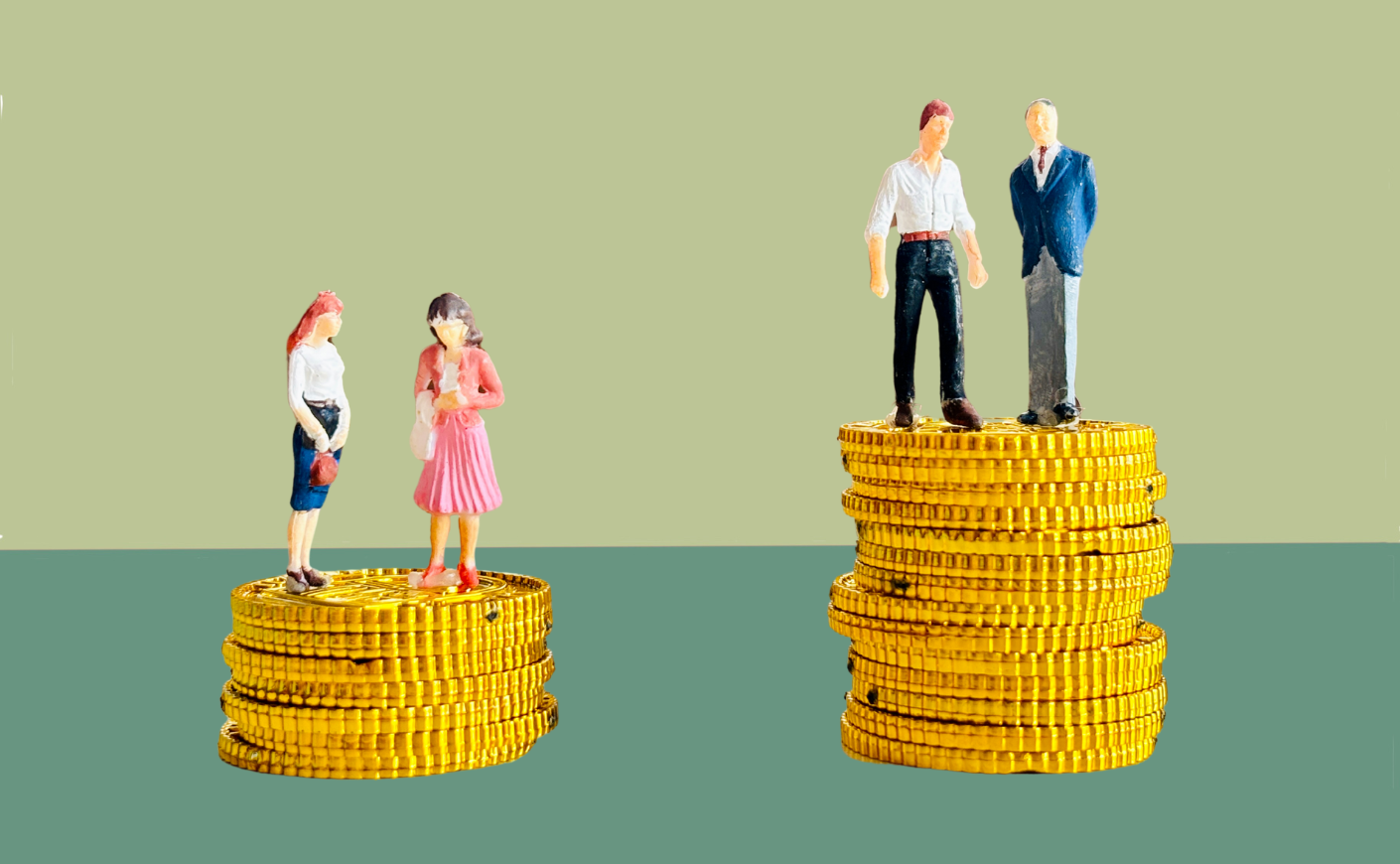 Two female dolls standing on top of a stack of coins next to two male dolls standing on a taller stack of coins