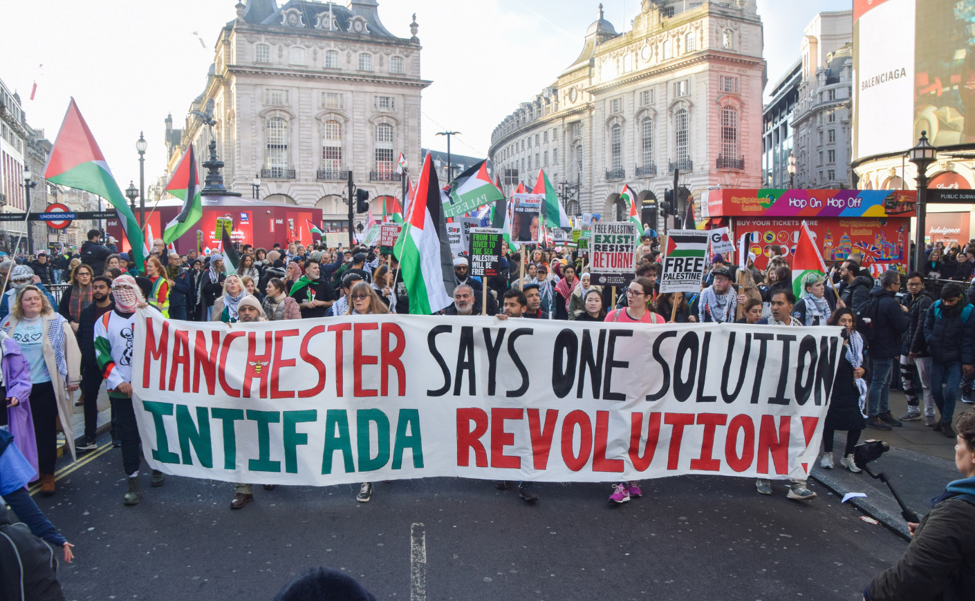Protesters holding a banner that says Manchester Says Only One Solution Intifada Revolution