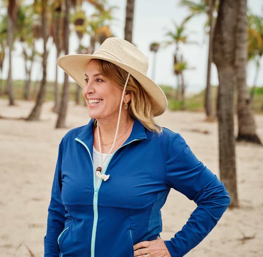 a woman on the beach wearing a sunhat