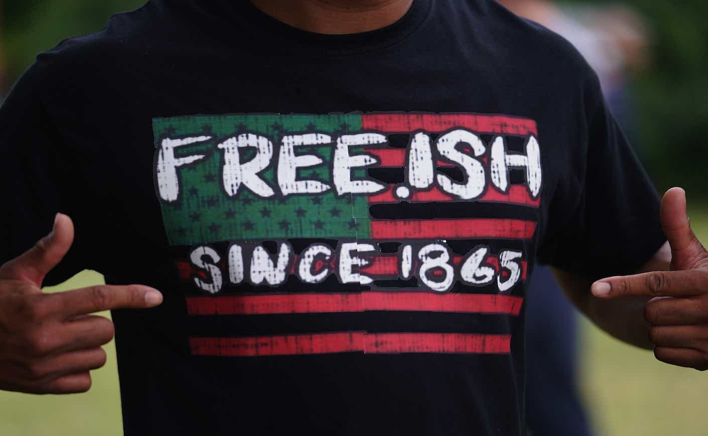 A man displays a shirt celebrating the freedom of enslaved Black people during the Juneteenth celebration in the Greenwood District on June 19, 2020 in Tulsa, Oklahoma