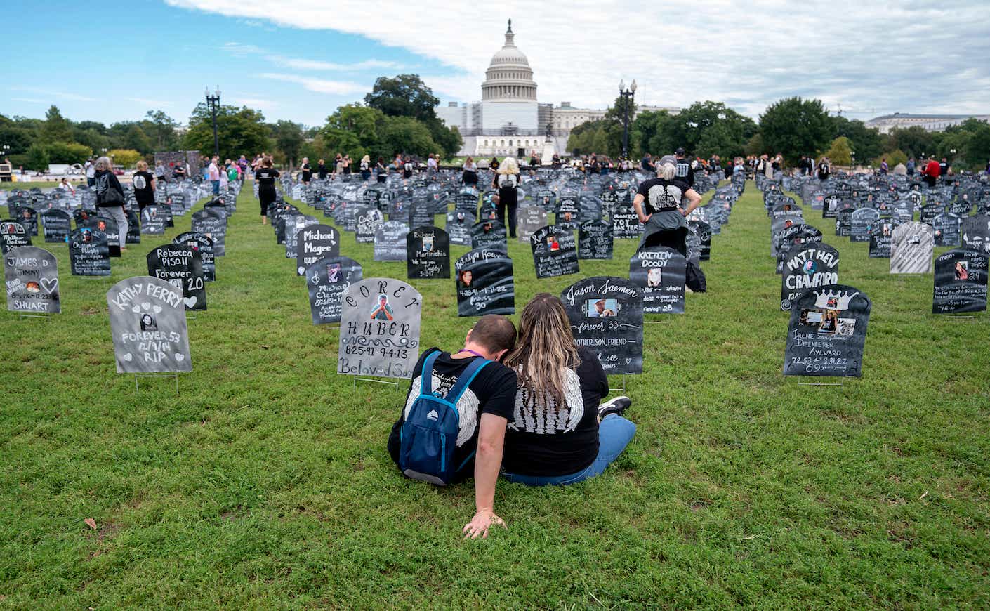 People who lost relatives to a drug overdose sit among imitation graves set up by the Trail of Truth, near the US Capitol in Washington, DC, on September 24, 2022. (Photo by Stefani Reynolds / AFP)