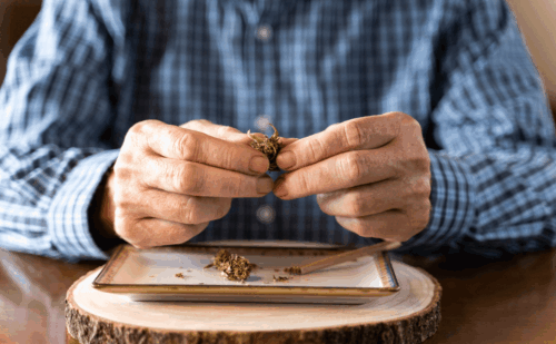 senior man rolling marijuana joint