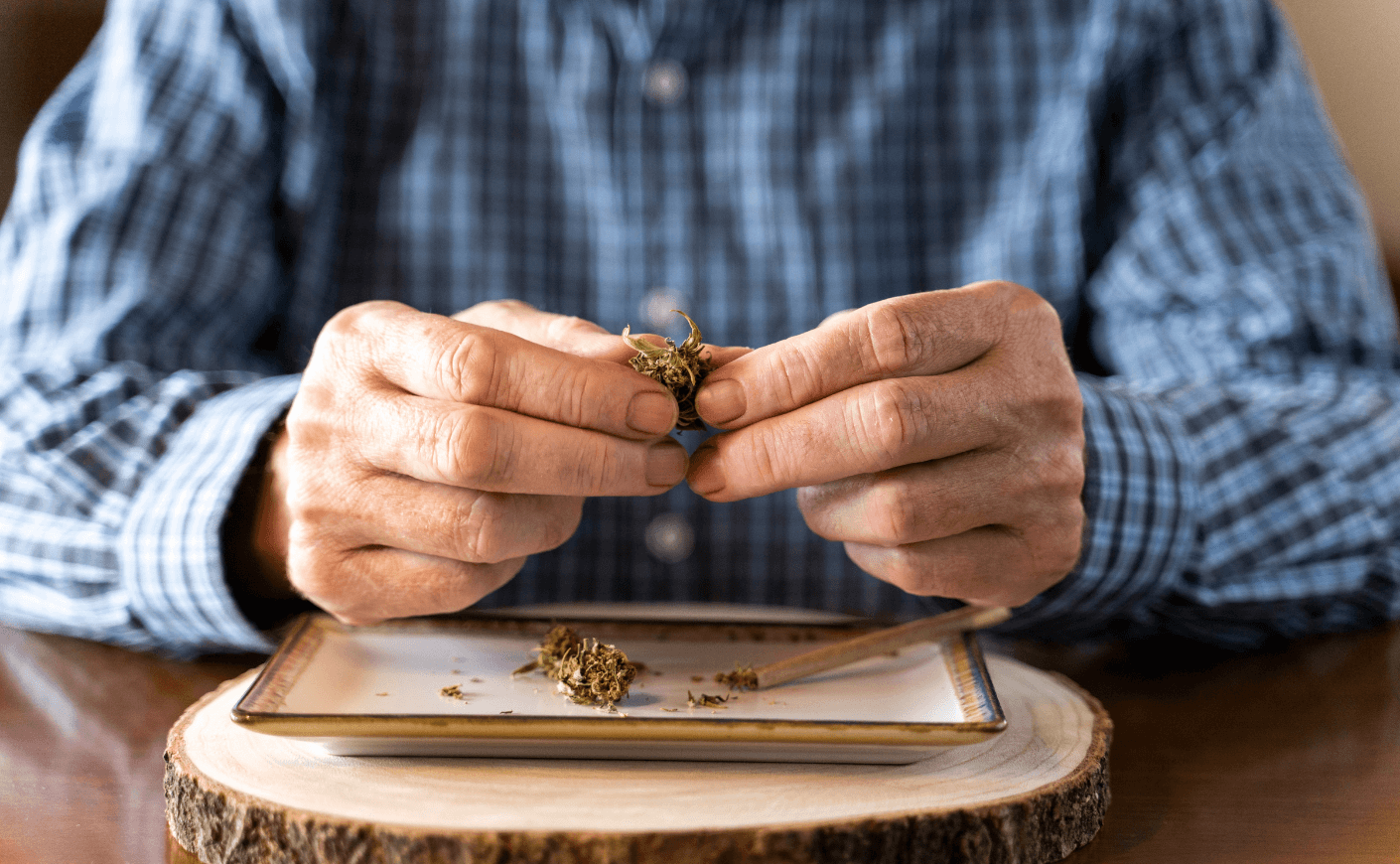 senior man rolling marijuana joint