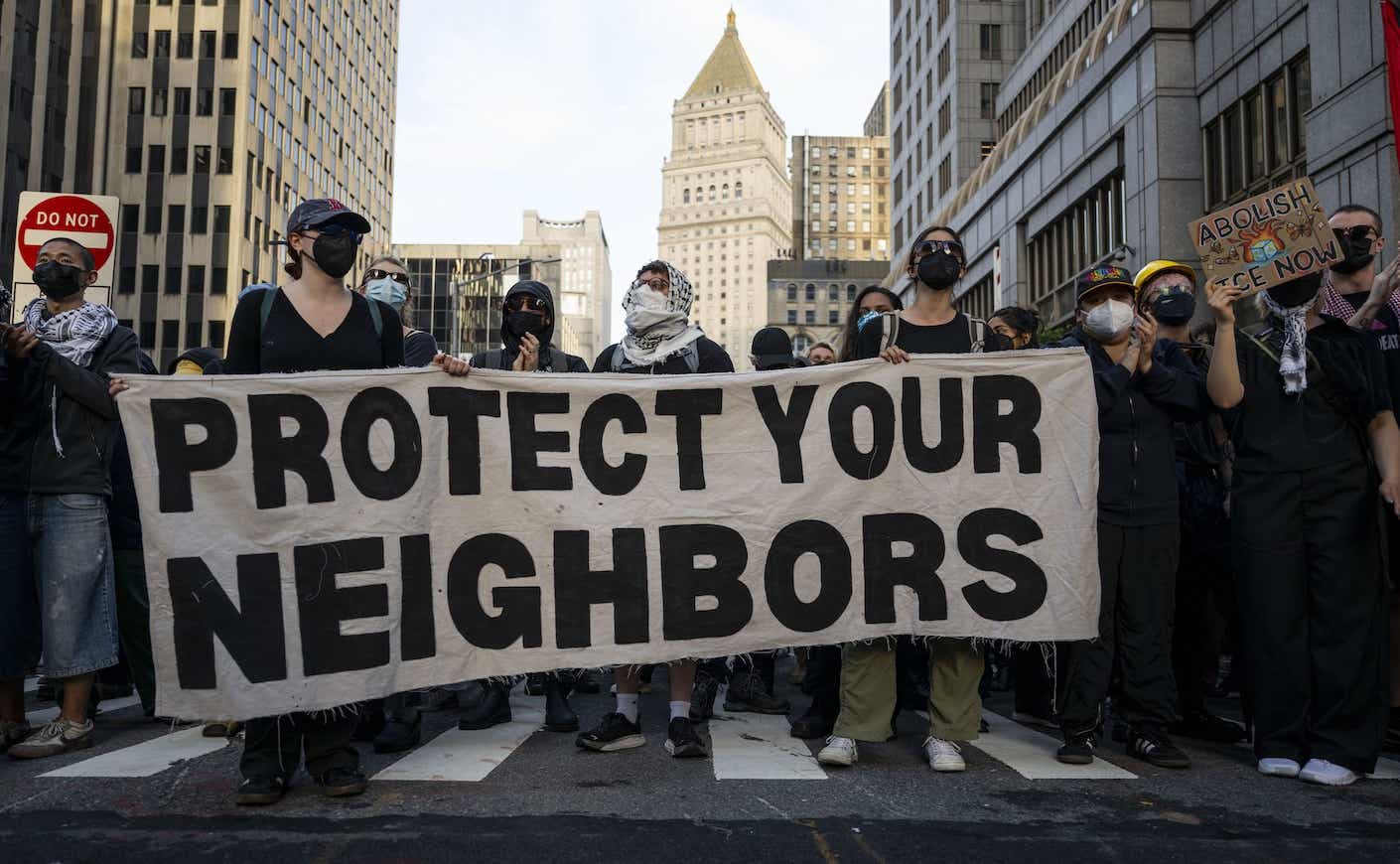 protestors holding a sign that says "protect your neighbors" in NYC