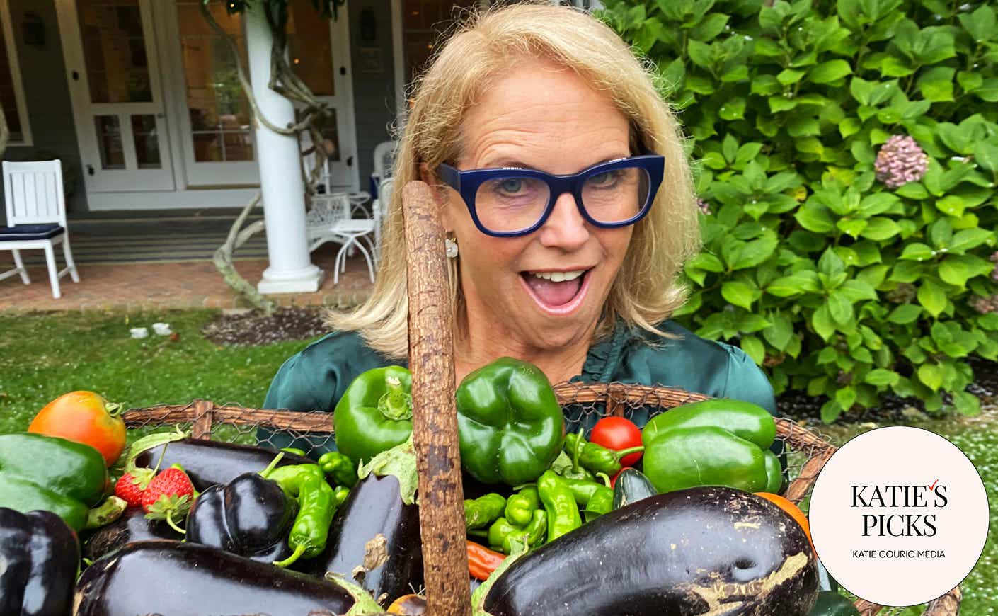 Katie Couric holding harvest basket full of veggies.