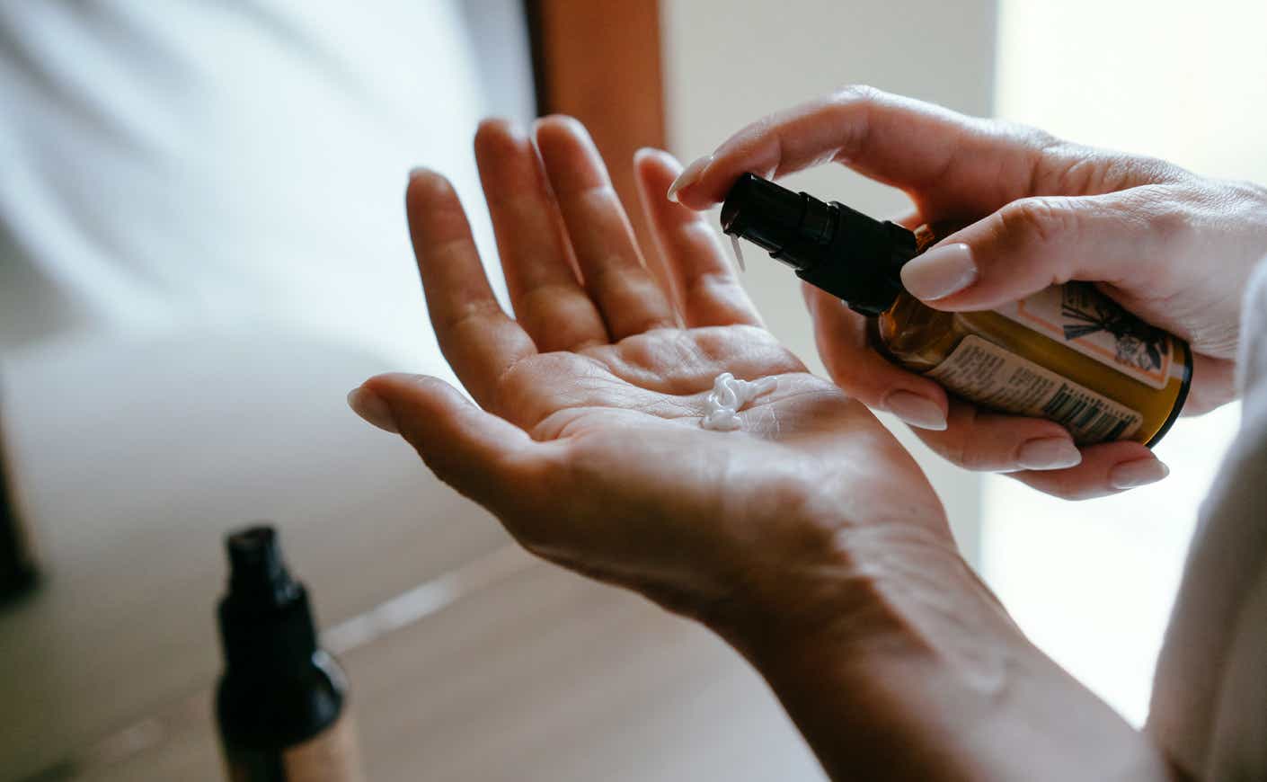 a person squirts lotion into their hand