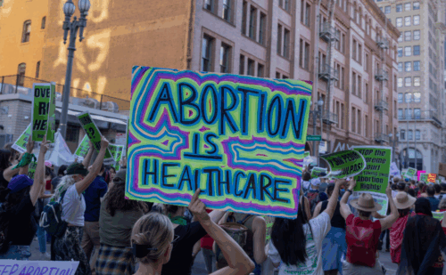A protestor holding a sign reading "Abortion is healthcare"