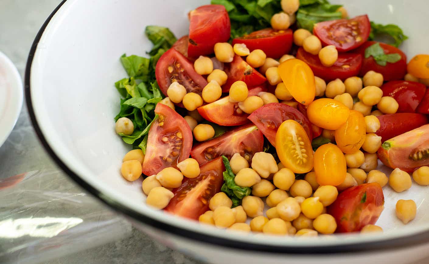 vegetable salad of tomatoes, chickpeas and lettuce in a bowl