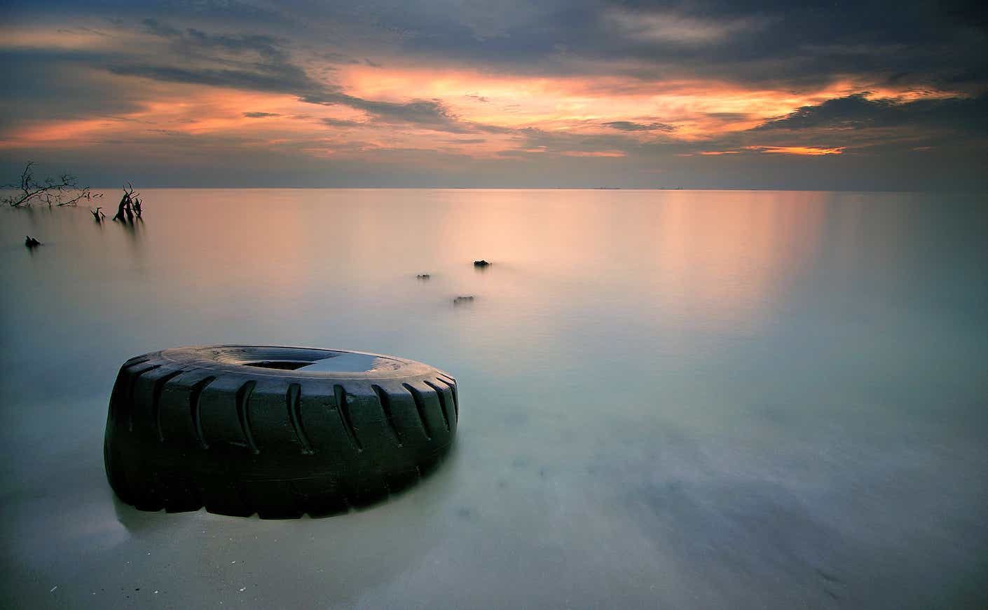 Tranquil Beach Point Sunset with a tire in the water