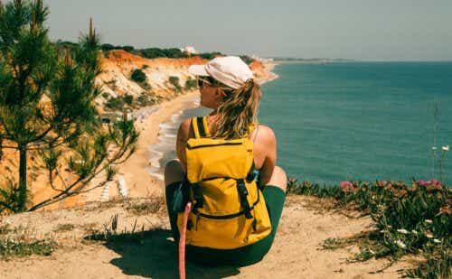 woman sitting on a hill overlooking a beach