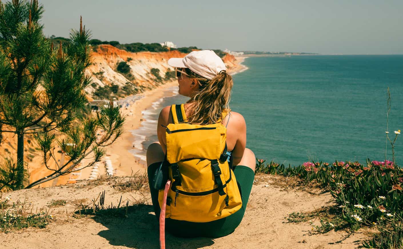 woman sitting on a hill overlooking a beach