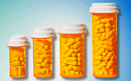 Bottles of pills arranged to represent a bar graph showing the rising cost of medicine and health care.