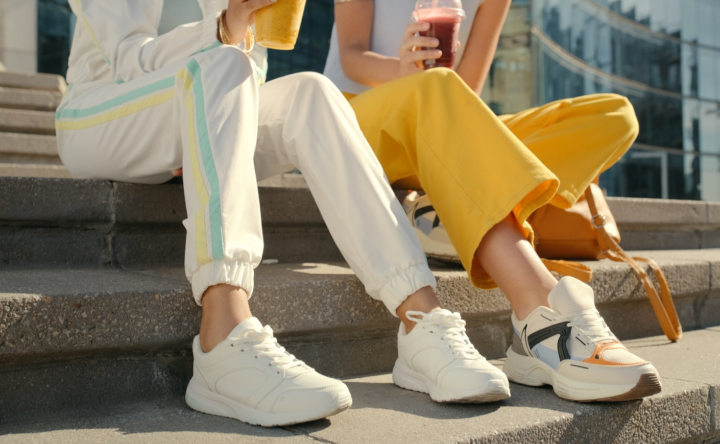 two people sitting on a step wearing sweatpants