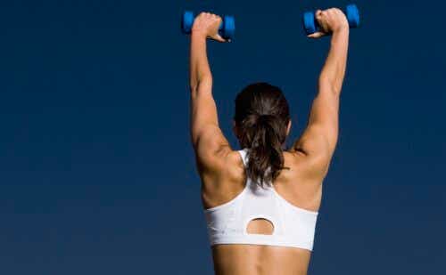 woman lifting light weights up to the sky