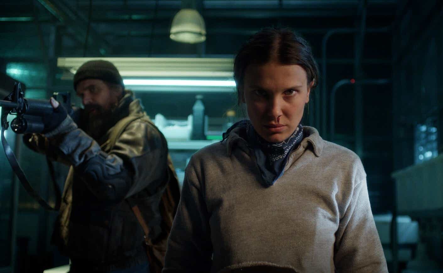 david harbour holding a rifle and millie bobby brown staring out as her nose bleeds in Stranger Things