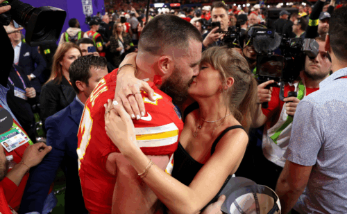 Taylor Swift and Travis Kelce kissing after a game