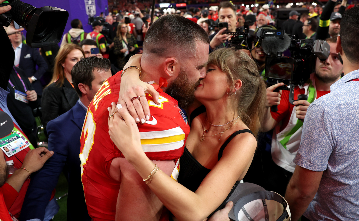 Taylor Swift and Travis Kelce kissing after a game