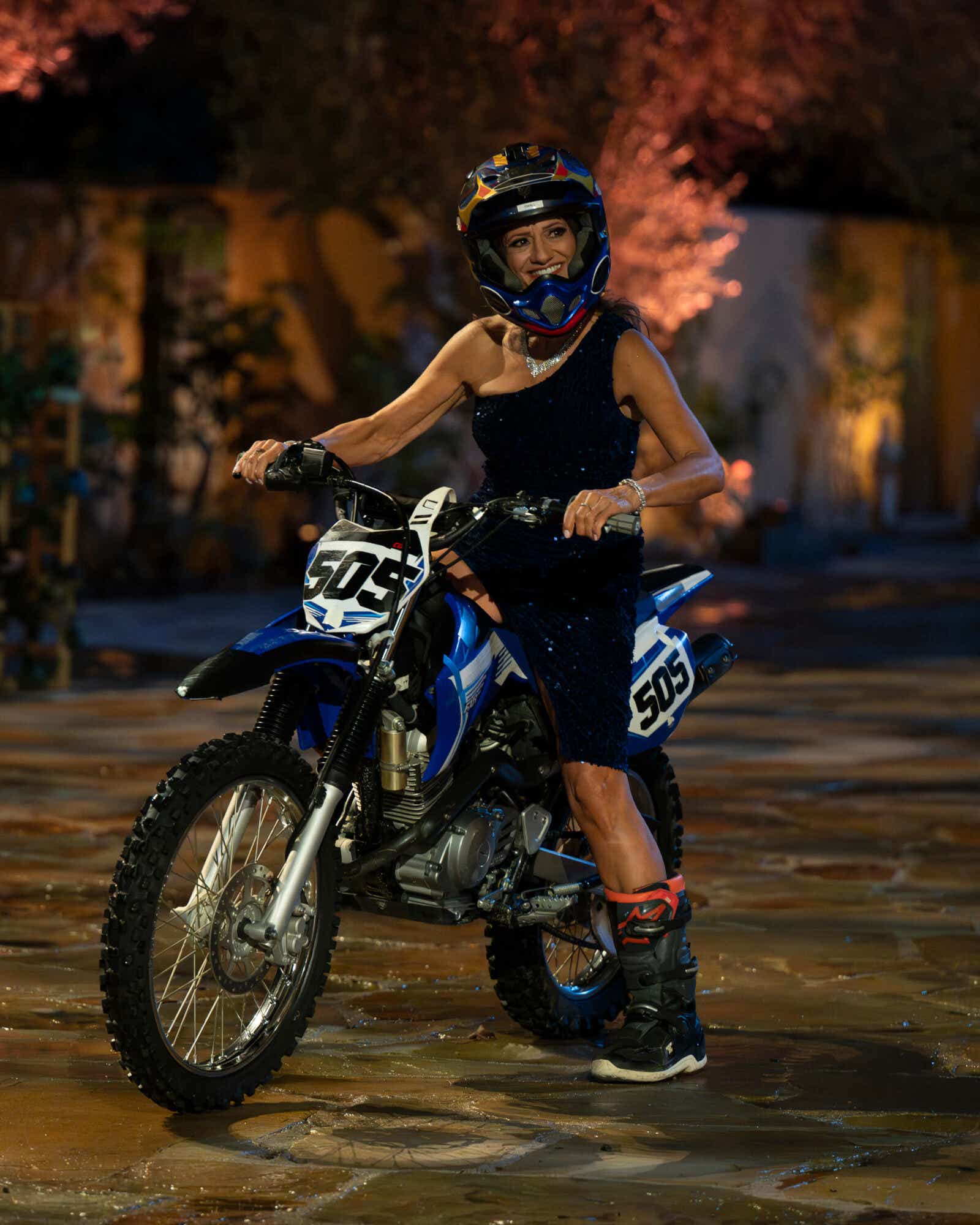 Cheryl pulls up to the bachelor mansion on a motorcycle