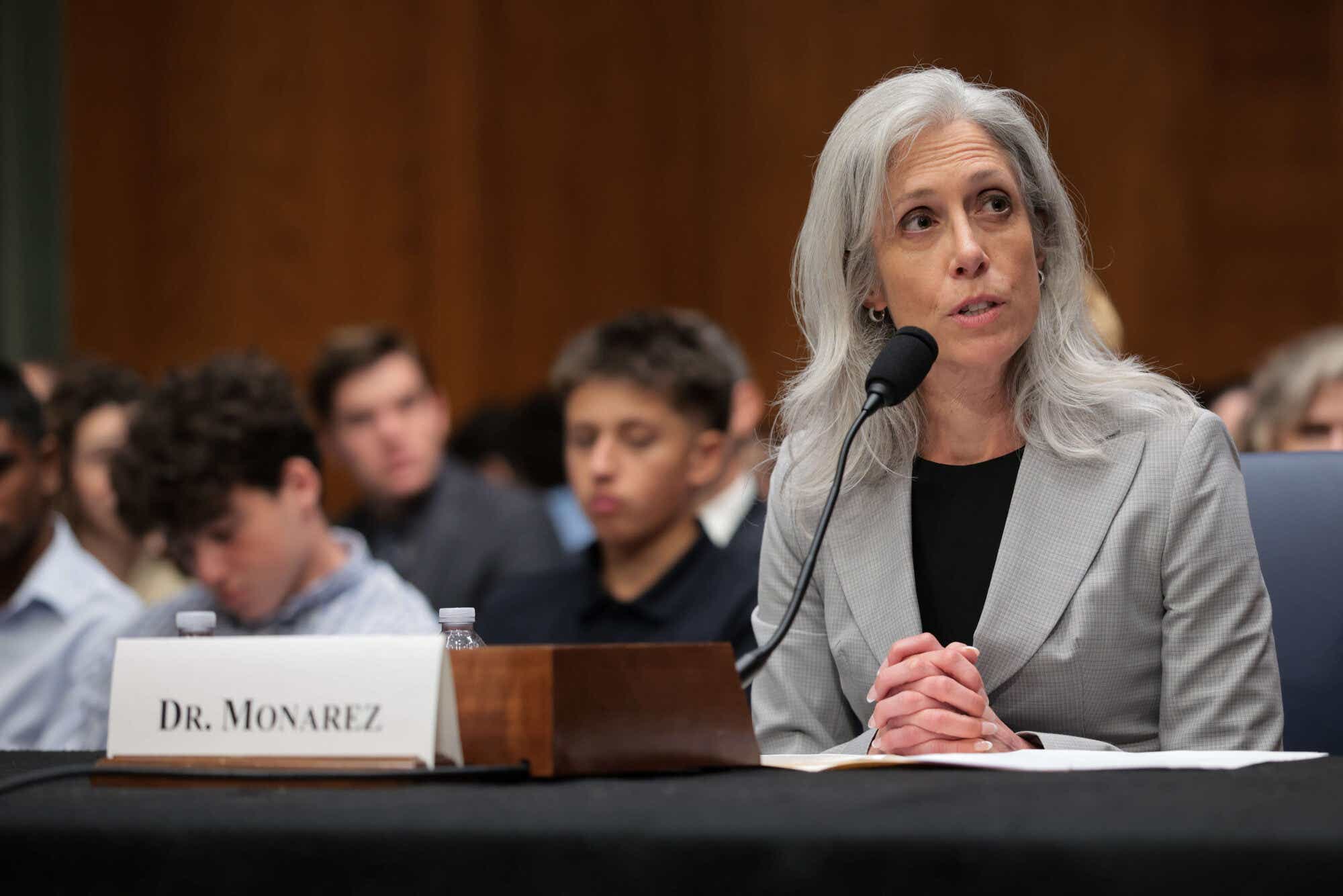 Dr. Susan Monarez testifying at her Senate confirmation hearing, wearing a gray blazer and black shirt underneath