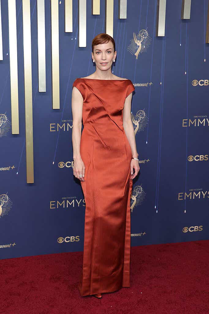 Britt Lower wears a burnt sienna off-the-shoulder gown
