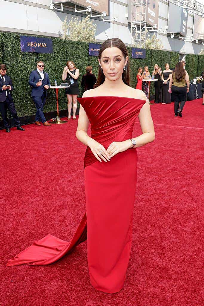 Cristin Milioti wears a red off-the-shoulder gown with a dramatic, architectural straight neckline.