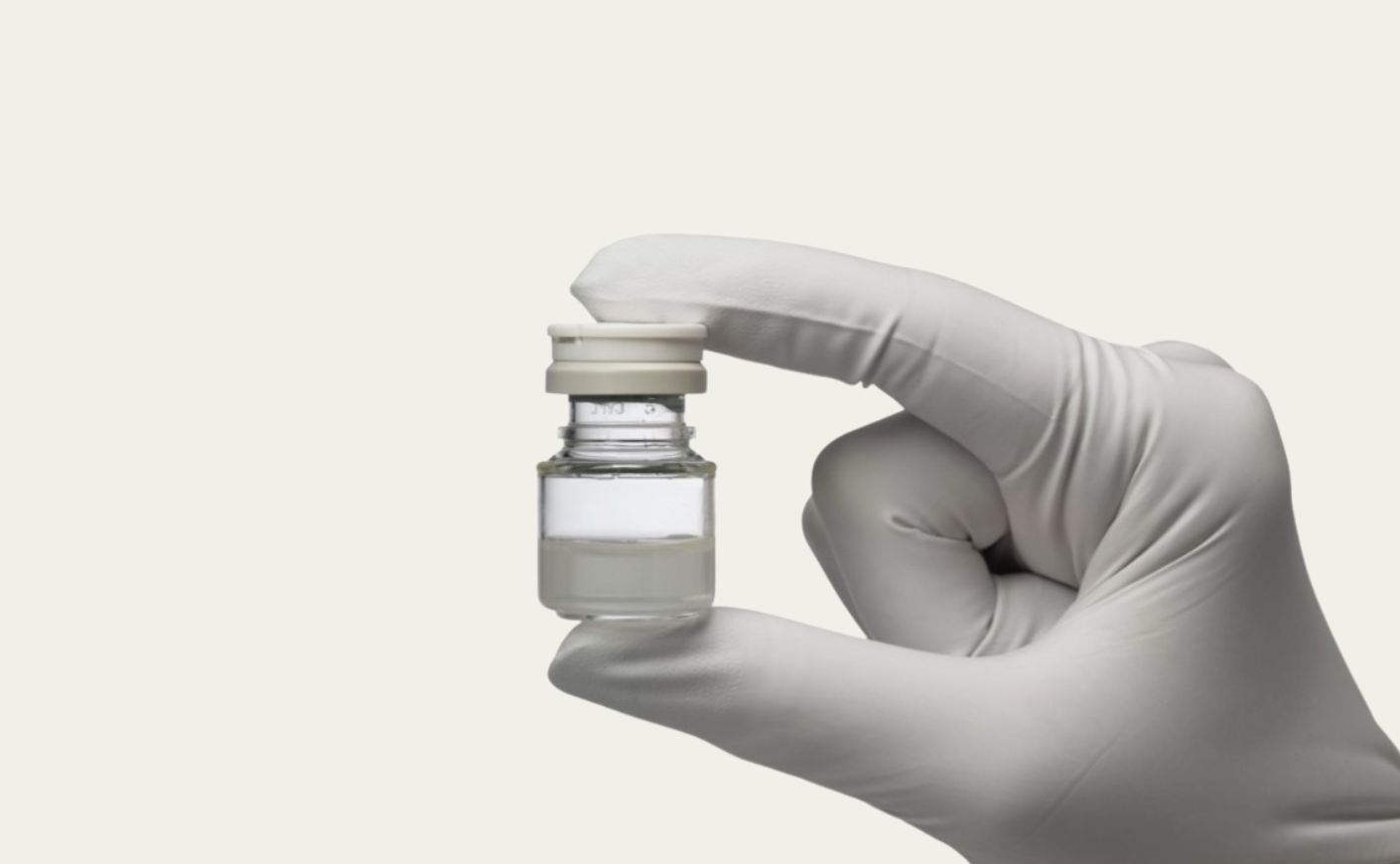 gloved hand holding vial
