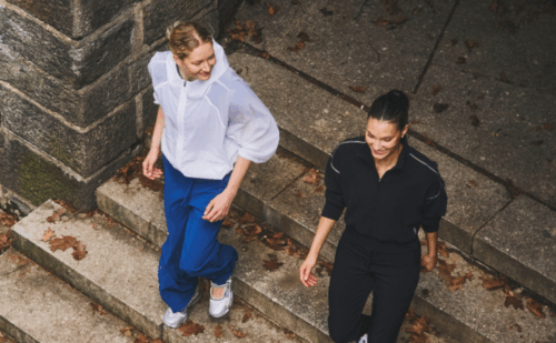 two women in workout clothes walking down steps
