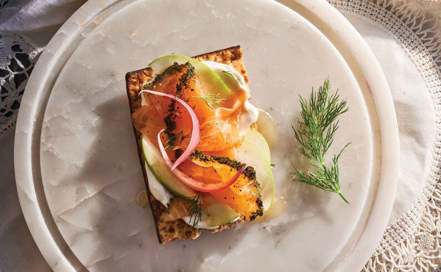 Elegant appetizer of gravlax, apples, Greek yogurt, and honey on crisp matzo.