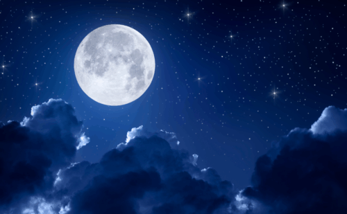 A full moon in the night sky with clouds and stars