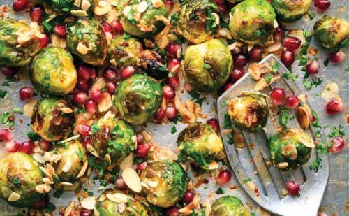 A tray of roasted Brussels sprouts sprinkled with pomegranate seeds.