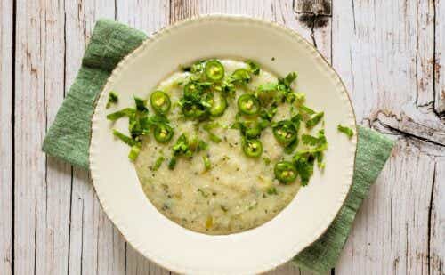 A bowl of grits garnished with green chiles.