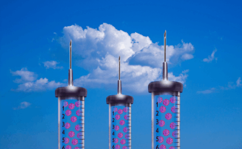 Three syringes filled with cells on a cloudy sky background