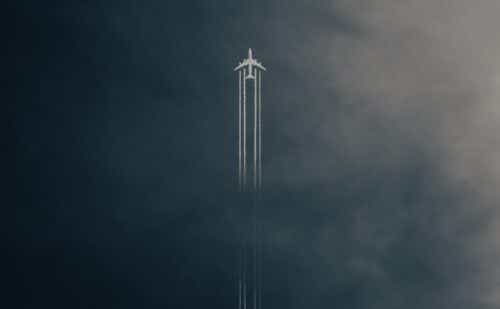 a plane flying upward and a vapor trail behind it