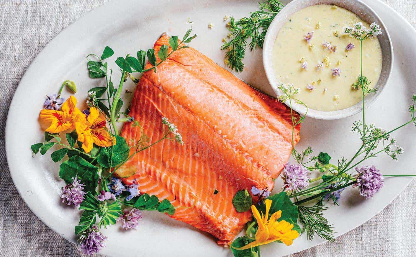 A plate of poached salmon and a dish of Hollandaise sauce.