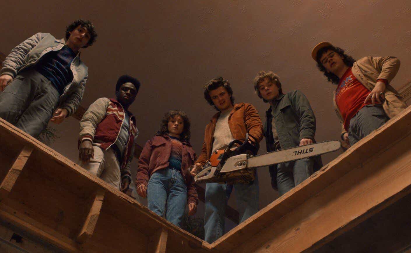 Stranger Things characters holding a chainsaw and looking down.