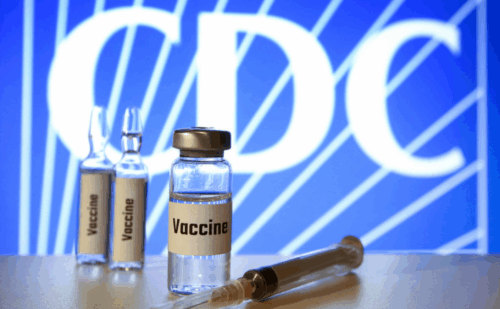 Vials of vaccines in front of the CDC logo