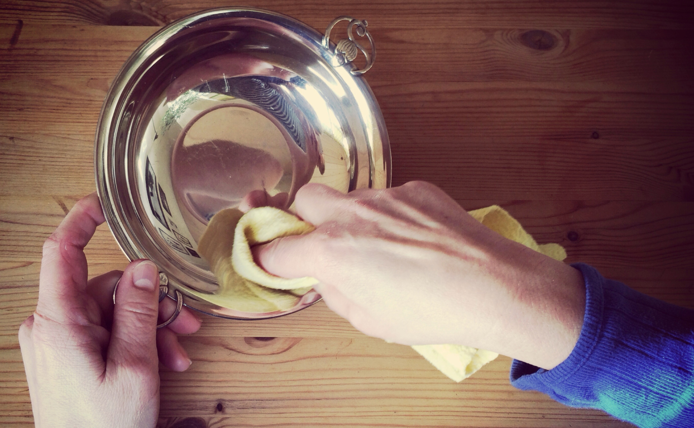 Hands polishing a silver bowl