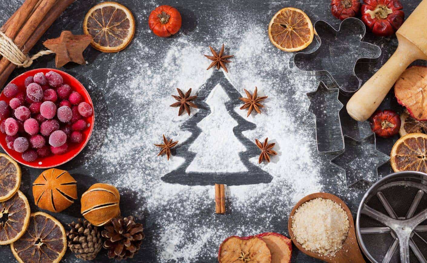 A Christmas tree outline traced in powdered sugar, surrounded by baking tools and accessories.
