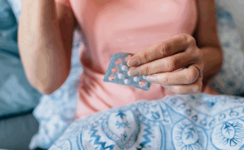 a woman holding pills