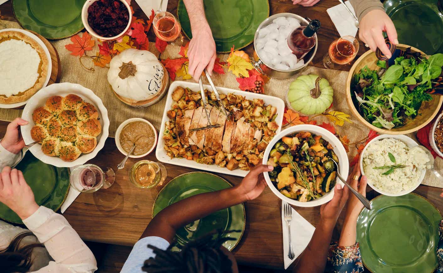 people gathered around a table eating thanksgiving dinner