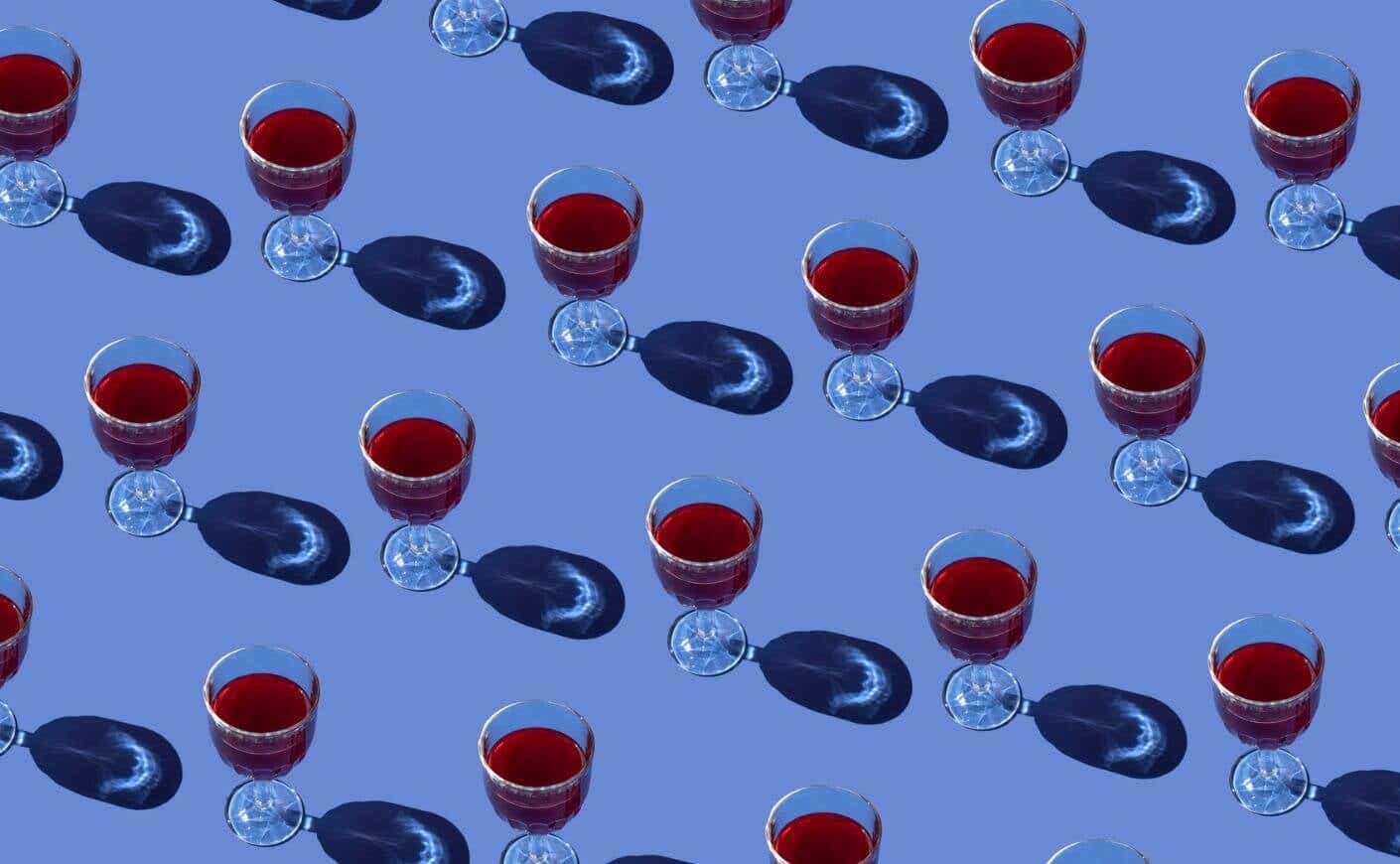 A grid of wine glasses filled with red wine.