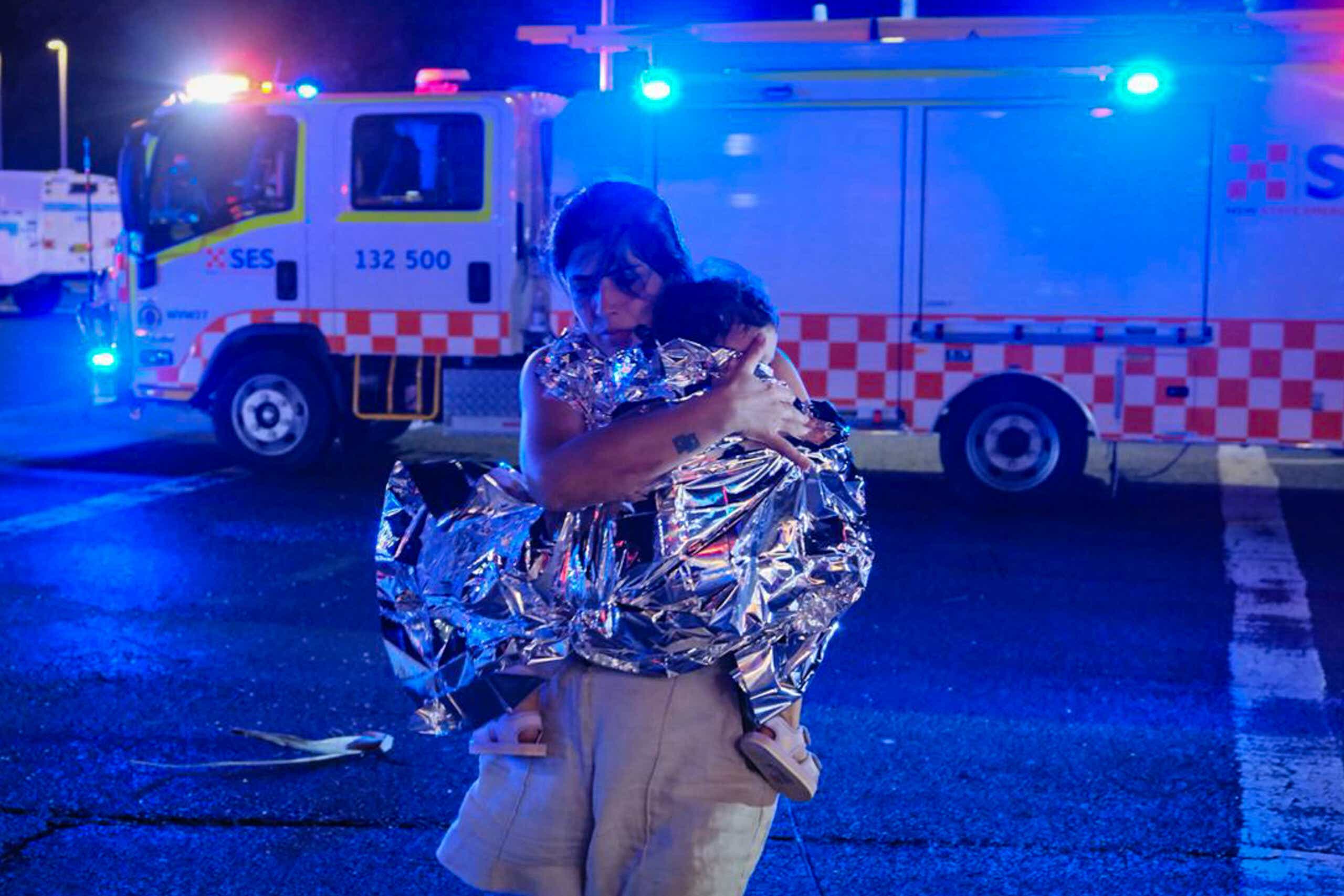 A woman holds her child after the antisemitic shooting in Bondi beach, Australia