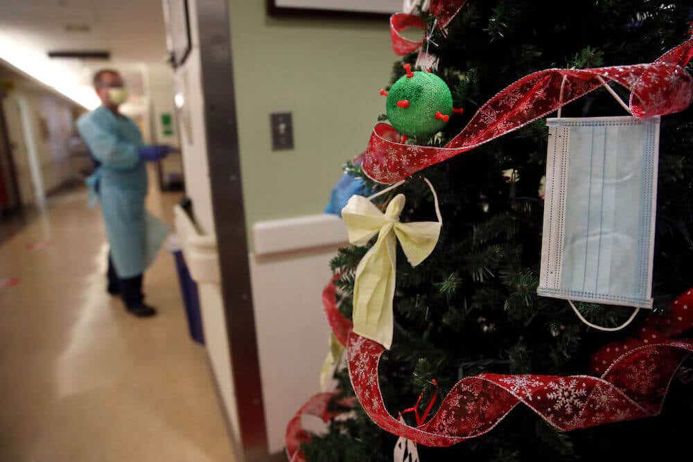 A Christmas tree in a hospital decorated with an ornament shaped like a Covid germ.