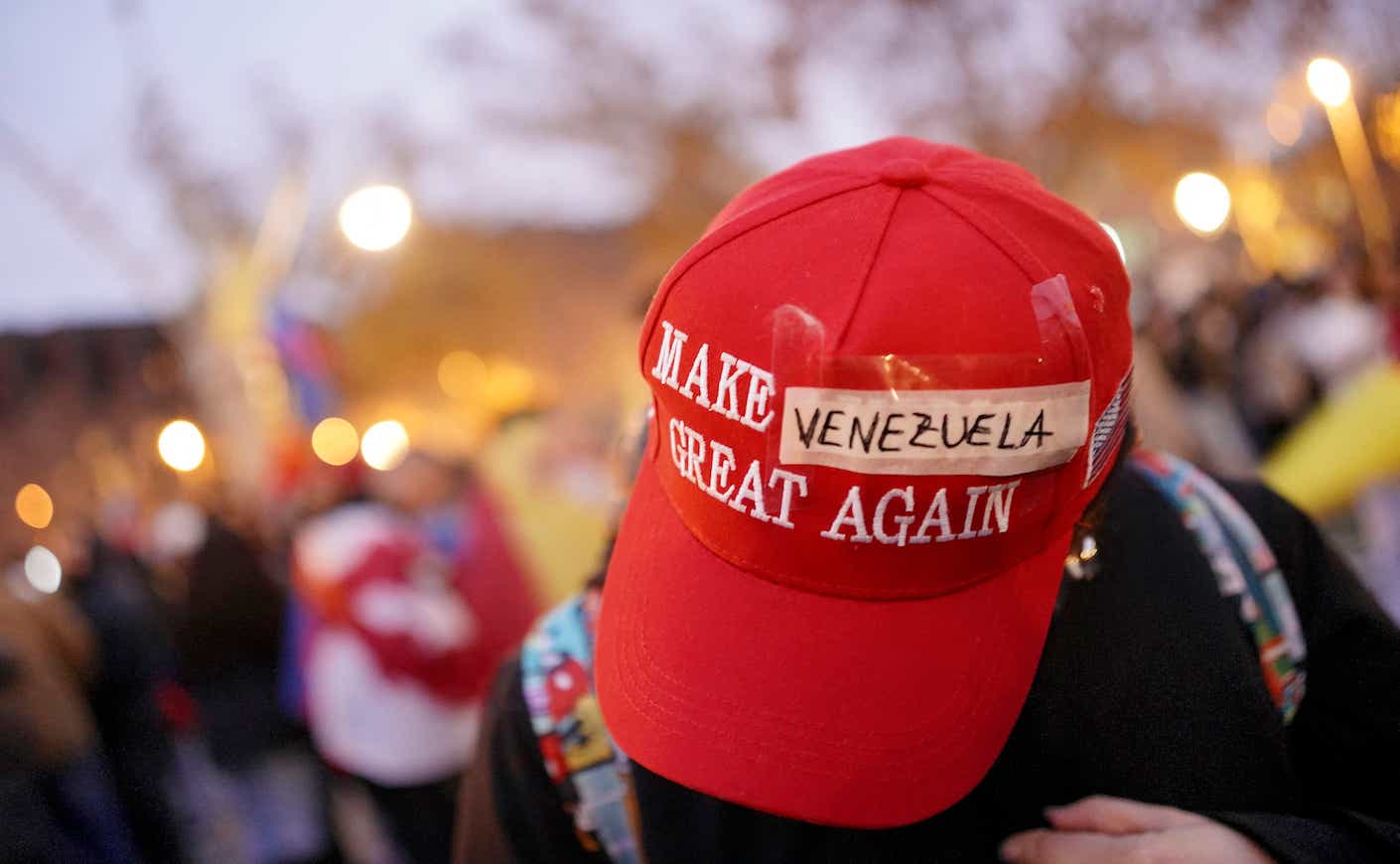 A protester wears a modified 'Make America Great Again' (MAGA) hat with 'Venezuela' taped over the original text during a demonstration in support of the Venezuelan people following the US military operation in Venezuela to capture the Venezuelan president, in Barcelona on January 4, 2026. Venezuela's president Nicolas Maduro was in a New York jail today after a shock US snatch-and-grab raid to remove him from power and assert Washington's control over the oil-rich South American nation. (Photo by Manaure Quintero / AFP)