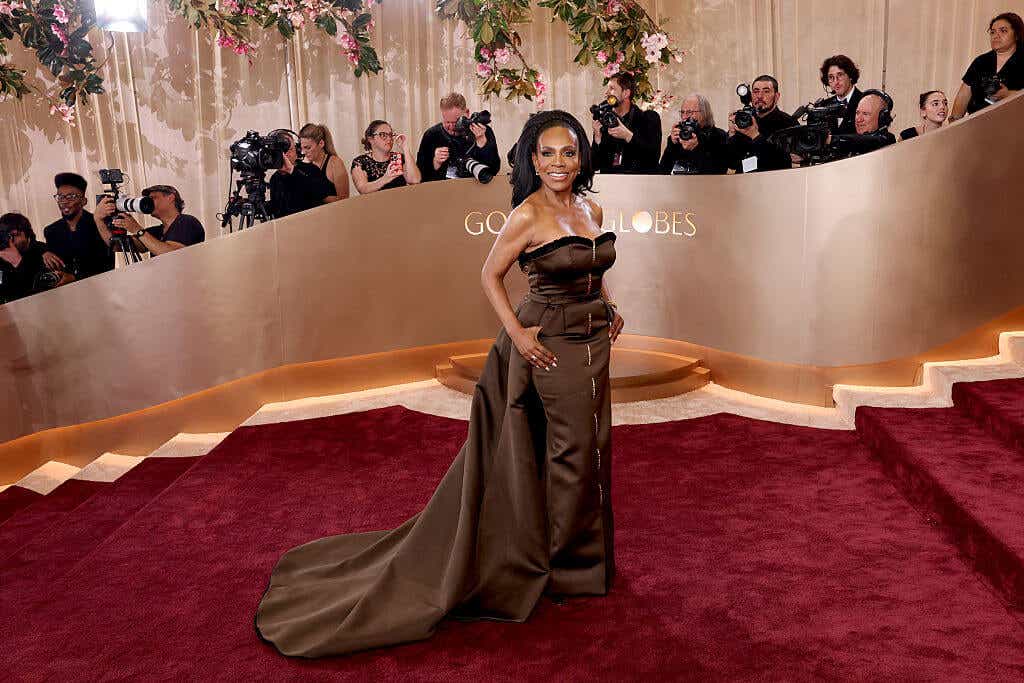 Sheryl Lee Ralph sports an off-the-shoulder brown dress with a zipper down the middle and a dramatic train.