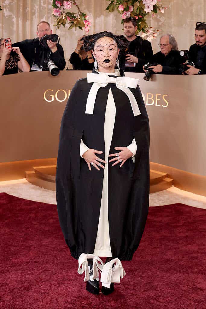 KPop Demon Hunters' Audrey Nuna wears a billowy black-and-white cape-like ensemble that ties at the ankles and has a big white bow at the neck