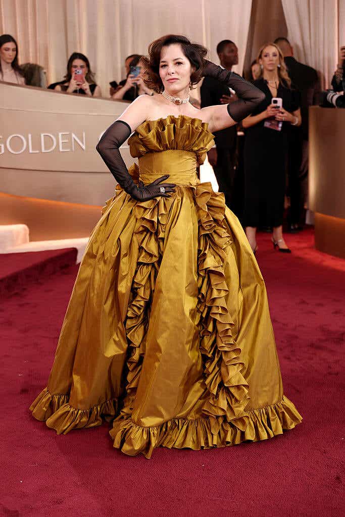 Parker Posey wears a ruffled voluminous gold ballgown