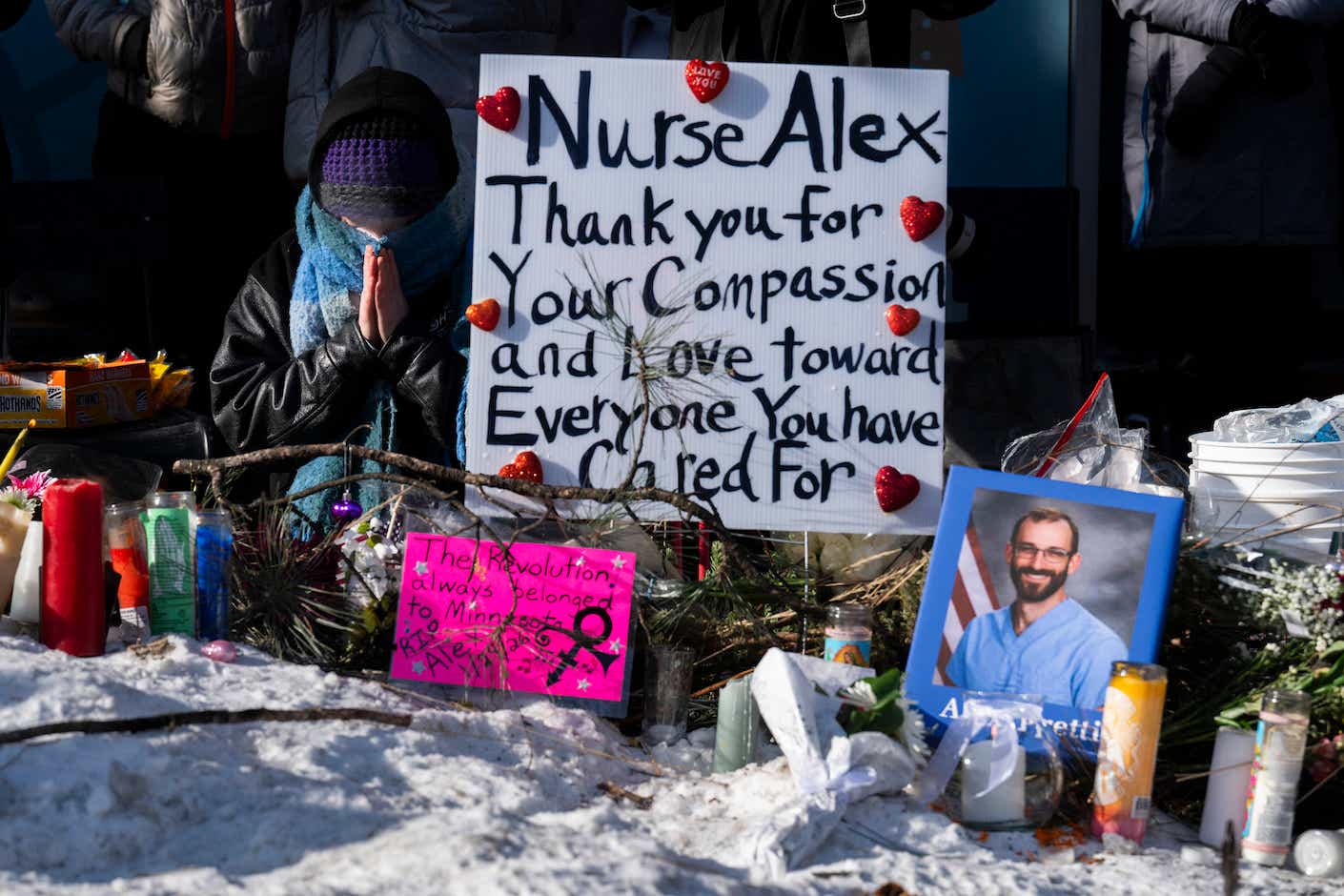 A mourner prays as people gather at a makeshift memorial in the area where Alex Pretti was shot dead a day earlier by federal immigration agents in Minneapolis, Minnesota, on January 25, 2026. On January 24, federal agents shot dead US citizen Alex Pretti, a 37-year-old ICU nurse, while scuffling with him on an icy roadway, less than three weeks after an