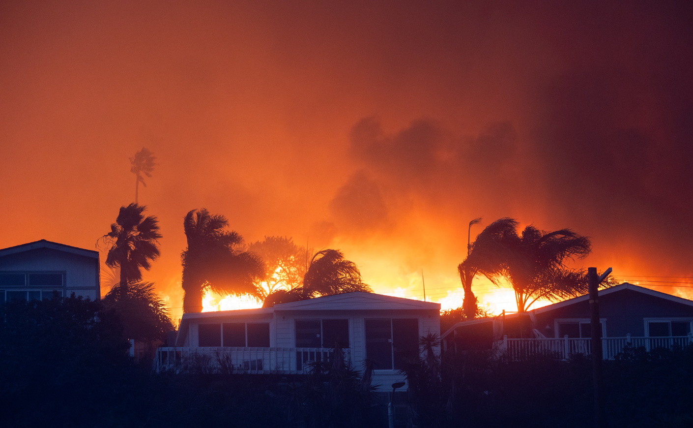 Fire blazes behind homes in LA's Pacific Palisades in 2025